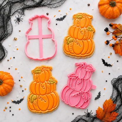 Halloween-themed cookies with pumpkin designs and cookie cutters on a decorative background.